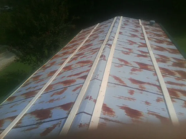 Rusted metal roof panels with new wood purlins before replacement — Storm Damage Roof Repair in Falls Church by Roofing Brothers
