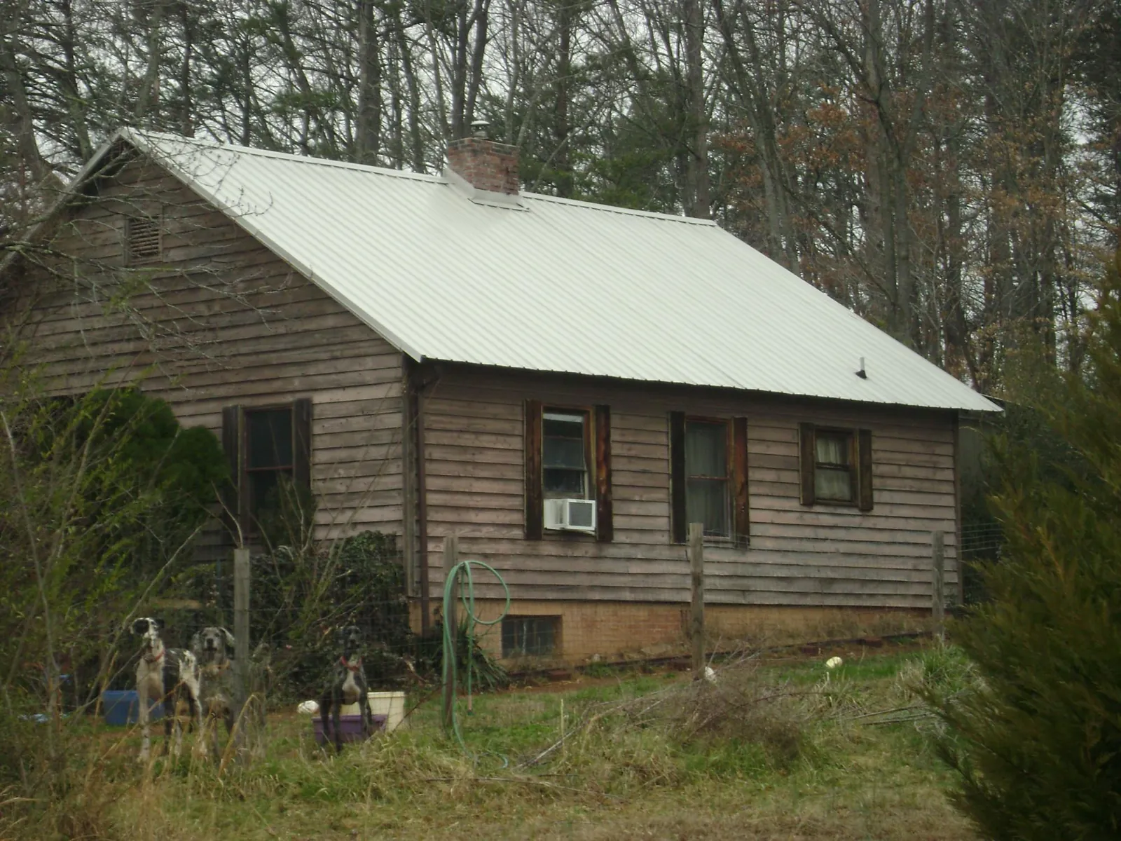 White metal roof on an old wood sided farmhouse, from a Metal Roof Installation job in Falls Church